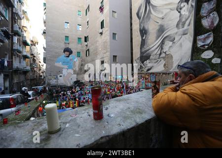 Un uomo guarda il gigantesco murale di Diego Armando Maradona nei quartieri spagnoli di Napoli, il giorno dopo la morte del famoso e leggendario AR Foto Stock