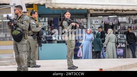 I poliziotti israeliani e una poliziotta in piedi armati, attenti, vicino alla porta di Damasco della città vecchia di Gerusalemme. Sullo sfondo ci sono pellegrini musulmani palestinesi. Crediti: Yoram Biberman/Alamy Live News. Foto Stock