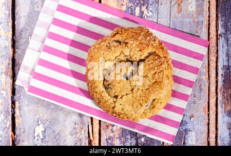 Un biscotto all'uva passa e all'avena in stile newyorkese fatto in casa. È un biscotto grande con crosta esterna croccante e un morbido centro in una borsa a strisce Foto Stock