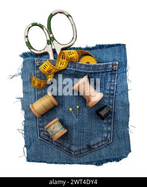 Materiali di consumo per cucire su sfondo bianco. Forbici, ditale, aghi e fili si trovano su un pezzo di denim strappato Foto Stock