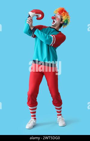 Ritratto di clown sorpreso con guanto da boxe su sfondo blu. Festa del giorno dello scemo d'aprile Foto Stock