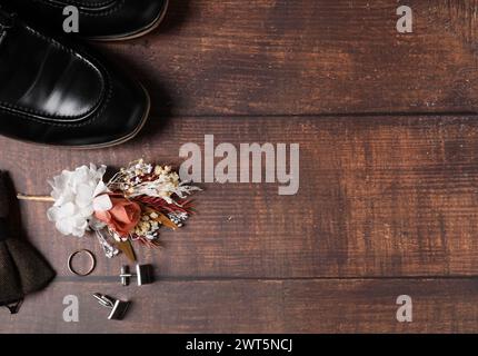 Roba per matrimoni. Composizione piatta con elegante boutonniere su sfondo in legno, spazio per il testo Foto Stock