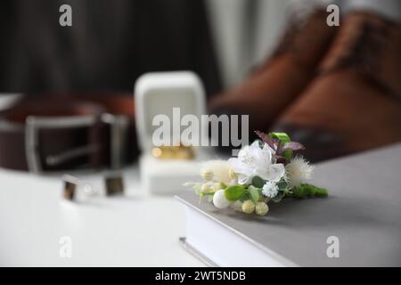 Roba per matrimoni. Composizione con elegante boutonniere su superficie bianca, primo piano Foto Stock