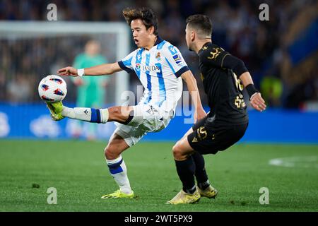 Takefusa Kubo del Real Sociedad gareggiano per il pallone con Javi Hernandez del Cadiz CF durante la partita LaLiga EA Sports tra Real Sociedad e Cadiz CF al reale Arena Stadium il 15 marzo 2024, a San Sebastian, in Spagna. Crediti: Cesar Ortiz Gonzalez/Alamy Live News Foto Stock
