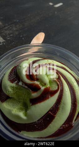 La foto è una foto di gelato al gusto di avocado in una tazza con sfondo nero Foto Stock