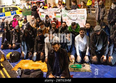 Londra, Regno Unito. 15 marzo 2024. I sostenitori religiosi filo-palestinesi sono visti pregare fuori dall'Ambasciata dell'Arabia Saudita a Londra per la preghiera di Taraweeh. I sostenitori pro-palestinesi si riuniscono fuori dall'Ambasciata dell'Arabia Saudita a Londra per la preghiera di Taraweeh il 4° giorno del Ramadan per pregare per coloro che hanno sofferto a causa della guerra israelo-Hamas. Condannano anche il governo saudita per non aver cercato abbastanza duramente di contribuire a portare la pace nella regione. (Foto di Hesther ng/SOPA Images/Sipa USA) credito: SIPA USA/Alamy Live News Foto Stock