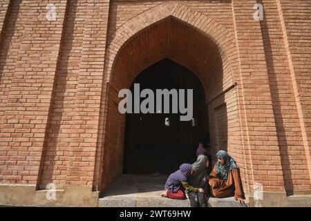 Srinagar, India. 15 marzo 2024. I bambini musulmani del Kashmir guardano mentre la gente offre le preghiere del venerdì all'interno della Jamia Masjid o della grande Moschea il primo venerdì del Ramadan. I musulmani di tutto il mondo stanno segnando il mese sacro del Ramadan, i fedeli digiunano dall'alba al tramonto. (Foto di Mubashir Hassan/Pacific Press) credito: Pacific Press Media Production Corp./Alamy Live News Foto Stock