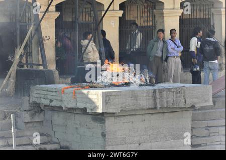 Persone che osservano una cerimonia di cremazione, Kathmandu Valley. Kathmandu, Nepal Foto Stock