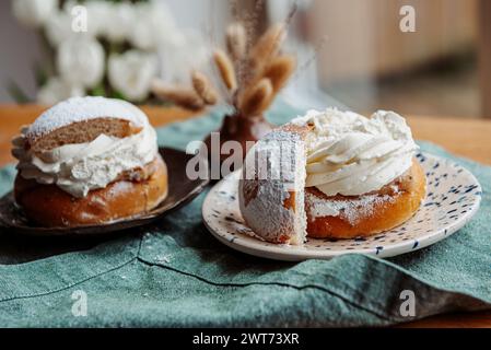 Tipica semla svedese con crema dolce su tessuto blu. Foto Stock