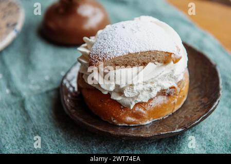 Tipica semla svedese con crema dolce su tessuto blu. Foto Stock
