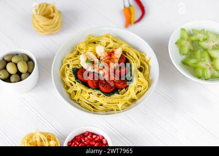 Spaghetti con spinaci, pomodori e gamberi. Specialità di pesce. Produzione domestica. Copia spazio Foto Stock