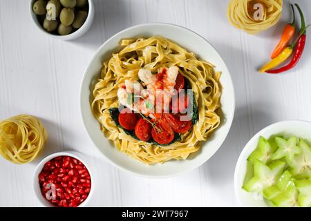 Spaghetti con spinaci, pomodori e gamberi. Specialità di pesce. Produzione domestica. Copia spazio Foto Stock