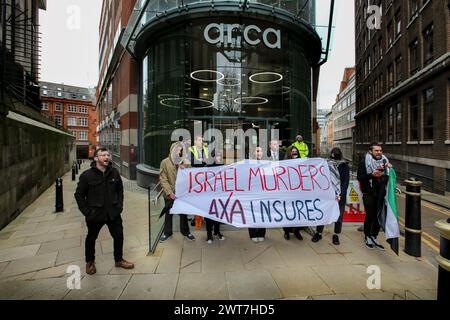 I manifestanti tengono uno striscione che dice che gli omicidi di ëIsrael, AXA Insuresí e cantano la loro disapprovazione fuori dagli uffici di AXAís durante la manifestazione. I manifestanti del fronte Giovanile per la Palestina (YFFP) e i loro sostenitori chiedono un boicottaggio dell'AXA, poiché affermano di investire oltre un miliardo di dollari in insediamenti illegali su quella che era una volta la terra palestinese e di tenere milioni in investimenti in tre banche israeliane. Affermano con questo sostegno finanziario che compagnie come AXA sono complici dei crimini di Israele contro i palestinesi a Gaza e altrove. Foto Stock