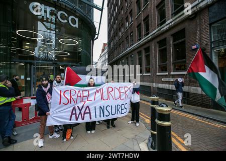 I manifestanti tengono uno striscione che dice che gli omicidi di ëIsrael, AXA Insuresí e cantano la loro disapprovazione fuori dagli uffici di AXAís durante la manifestazione. I manifestanti del fronte Giovanile per la Palestina (YFFP) e i loro sostenitori chiedono un boicottaggio dell'AXA, poiché affermano di investire oltre un miliardo di dollari in insediamenti illegali su quella che era una volta la terra palestinese e di tenere milioni in investimenti in tre banche israeliane. Affermano con questo sostegno finanziario che compagnie come AXA sono complici dei crimini di Israele contro i palestinesi a Gaza e altrove. Foto Stock