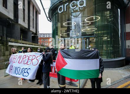 Birmingham, Regno Unito. 14 marzo 2024. I manifestanti tengono uno striscione che dice omicidi di ëIsrael, AXA Insuresí fuori dagli uffici di AXAís durante la manifestazione. I manifestanti del fronte Giovanile per la Palestina (YFFP) e i loro sostenitori chiedono un boicottaggio dell'AXA, poiché affermano di investire oltre un miliardo di dollari in insediamenti illegali su quella che era una volta la terra palestinese e di tenere milioni in investimenti in tre banche israeliane. Affermano con questo sostegno finanziario che compagnie come AXA sono complici dei crimini di Israele contro i palestinesi a Gaza e altrove. Credito: SOPA Images Limited/Alamy Live News Foto Stock