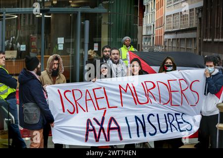 I manifestanti tengono uno striscione che dice che gli omicidi di ëIsrael, AXA Insuresí e cantano la loro disapprovazione fuori dagli uffici di AXAís durante la manifestazione. I manifestanti del fronte Giovanile per la Palestina (YFFP) e i loro sostenitori chiedono un boicottaggio dell'AXA, poiché affermano di investire oltre un miliardo di dollari in insediamenti illegali su quella che era una volta la terra palestinese e di tenere milioni in investimenti in tre banche israeliane. Affermano con questo sostegno finanziario che compagnie come AXA sono complici dei crimini di Israele contro i palestinesi a Gaza e altrove. Foto Stock