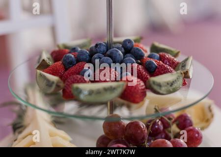 Un assortimento di frutta fresca esposta elegantemente su un banco di vetro Foto Stock