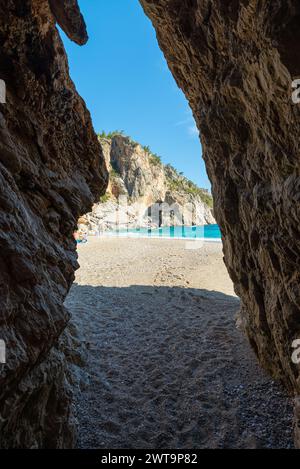 Grotta sulla spiaggia. Vista dall'interno di una grotta sulla spiaggia dell'isola di Karpathos, in Grecia. Foto Stock