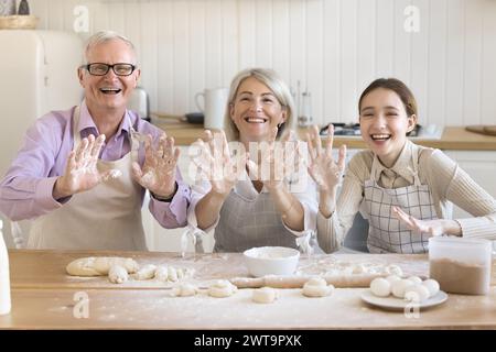 Nonno, figlia e nipote che si divertono, divertiti a cucinare a casa Foto Stock
