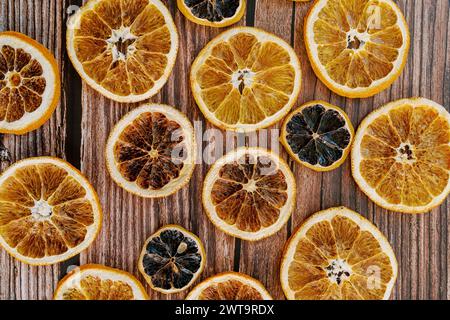 Pezzi di arance secche gialle e nere si trovano su un tavolo di legno Foto Stock
