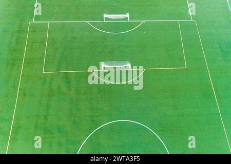 Un campo da calcio con due gol e una panchina. Il campo è verde e ben tenuto. Concetto di sportività e lavoro di squadra Foto Stock