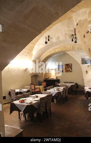 Matera, Italia. Interno di un ristorante negli antichi Sassi di Matera, ricavato da un'antica dimora scavata nella roccia. Foto Stock