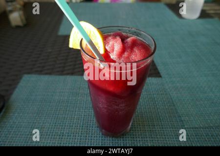 Bevanda tropicale congelata con fetta d'arancia e cannuccia da bere sul tavolo del ristorante all'aperto Foto Stock