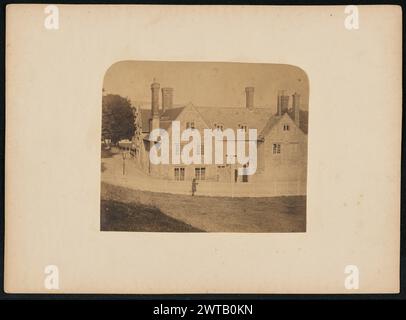 Southover Priory, sede di W.C. Mabbott, Scudiero John Thomas Case, fotografo (britannico, nato intorno al 1819) 1857 Un uomo in piedi davanti alla recinzione di fronte al Southover Priory, ora conosciuto come Southover Grange. La proprietà apparteneva a William Courthorpe Mabbott e a sua moglie Elizabeth. La casa è in pietra e ha due finestre dormienti al centro del tetto. Sono presenti più camini raggruppati su entrambe le estremità del tetto. Foto Stock