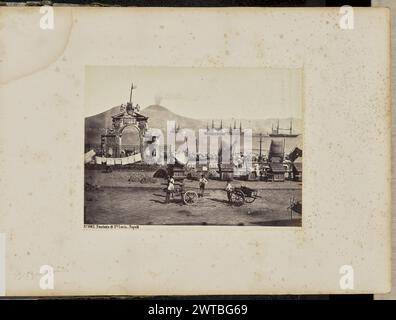 Fontana di Santa Lucia. Napoli. Giorgio Sommer, fotografo (italiano, nato in Germania, 1834 - 1914) anni '1860-'1870 veduta di un'area sul lungomare che presenta un arco ornato e una fontana d'acqua, oltre a bancarelle in legno. L'arco e la fontana sono racchiusi da una recinzione di ferro. Alcune persone sono in piedi su una strada asfaltata in primo piano, alcune delle quali trasportano carrelli. Il Vesuvio e un certo numero di grandi navi sono visibili sullo sfondo. (Recto, Mount) in basso a sinistra, a matita: "Georgio [sic] Sommer?"; Foto Stock
