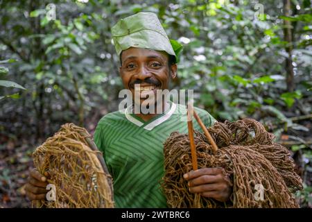 Pigmeo del popolo Baka o BaAka con le sue trappole e le reti da caccia nella foresta, riserva forestale densa speciale Dzanga-Sangha, Sangha-Mbaere Foto Stock