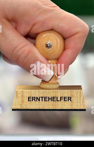 Foto simbolo, mano della donna con francobollo, iscrizione: Harvester, studio Foto Stock