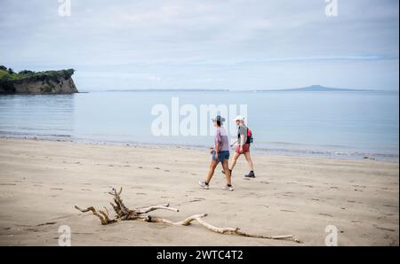 Due donne fanno escursioni nel parco regionale shakespeariano e a Rangitoto Island in lontananza. Auckland. Foto Stock