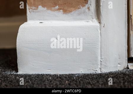 primo piano del battiscopa in legno verniciato durante la ristrutturazione della casa. Foto Stock