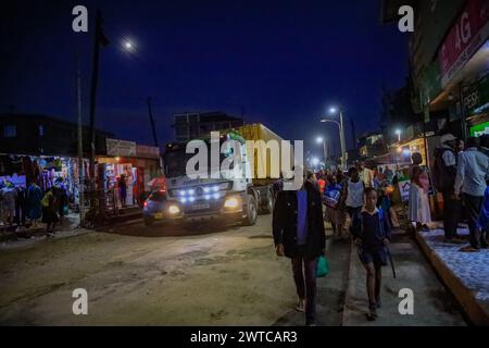 La gente del posto torna a casa dal lavoro lungo le strade trafficate di Kibera Slum, Nairobi. Kibera, il più grande slum di Nairobi e Africa, è hom Foto Stock