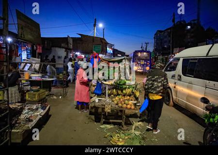 La gente del posto torna a casa dal lavoro lungo le strade trafficate di Kibera Slum, Nairobi. Kibera, il più grande slum di Nairobi e Africa, è hom Foto Stock