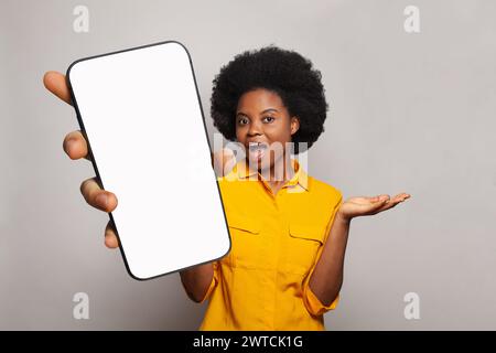 La donna eccitata tiene un telefono con display vuoto. Donna con smartphone Foto Stock