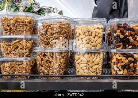 Noci e mandorle sgusciate e noci miste in scatole di plastica trasparente esposte per la vendita al supermercato Foto Stock