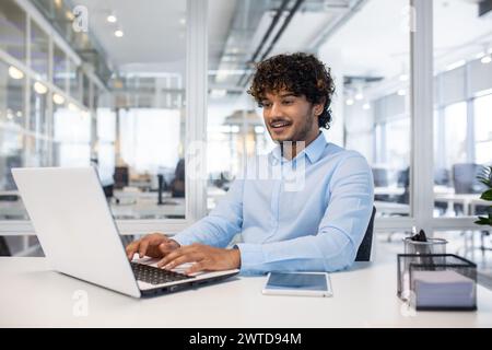 Professionisti concentrati che lavorano su un notebook in un ufficio luminoso e moderno, che incarna produttività e stile di vita aziendale. Foto Stock