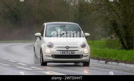 Milton Keynes, UK-17 marzo 2024: 2021 Fiat 500 Dolcevita bianca che guida sotto la pioggia Foto Stock