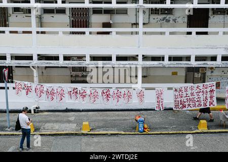 Hong Kong, Cina. 17 marzo 2024. Striscioni e camicie con il carattere cinese "miserabile" sono esposti presso la tenuta di Tai Hang Sai. Costruita nel 1965, la tenuta di Tai Hang Sai è stata originariamente progettata per fornire alloggi ai residenti sfollati dall'autorizzazione dell'area di reinsediamento di Tai Hang Sai. Con oltre 1.600 unità a prezzi inferiori a quelli di mercato, è l'unica proprietà privata di Hong Kong. Attualmente sono in atto piani per demolire e riqualificare la tenuta, con il completamento stimato per il 2029. Si prevede che la riqualificazione fornisca più di 3.300 unità. (Cred Foto Stock