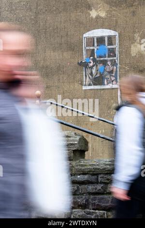 Le persone che camminano oltre Banksys Picture Well Hung Lover su Park st Bristol Foto Stock