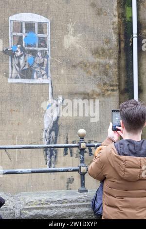 Giovane che scatta una foto al telefono di Banksys Well Hung Lover a Park st Bristol Foto Stock