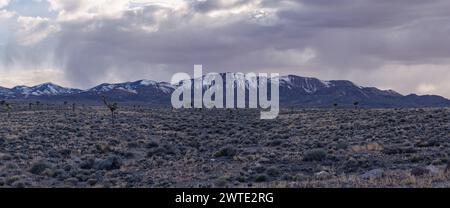 Montagne innevate in lontananza sotto nuvole minacciose Foto Stock