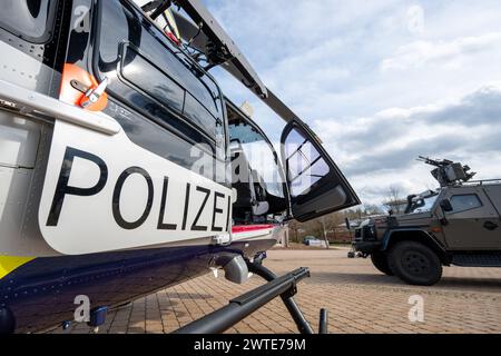 Sulzbach Rosenberg, Germania. 17 marzo 2024. Il veicolo offensivo corazzato Enok 6,2 delle forze speciali si trova accanto al nuovo elicottero Airbus H145 D3 sul terreno della polizia antisommossa durante la grande esercitazione internazionale. Le unità speciali di polizia e doganali, nonché i membri delle forze armate tedesche, i servizi di soccorso, i vigili del fuoco e l'organizzazione tecnica di soccorso partecipano all'esercitazione antiterrorismo "lotta al terrorismo 2024”. Crediti: Armin Weigel/dpa/Alamy Live News Foto Stock