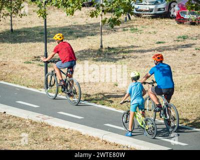 Bucarest, Romania - 16 settembre 2023: Famiglia con bambini in bicicletta sulla nuova pista ciclabile intorno al lago Dambovita (Lacul Morii), a Bucarest. Foto Stock