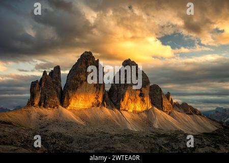 Famoso massiccio roccioso tre Cime di Lavaredo (Drei Zinnen) la sera estiva e il tramonto con nuvole colorate sulle vette. Posizione Place Italian Alps Foto Stock