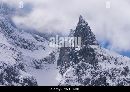 Picco roccioso di Mnich nella nuvolosa giornata invernale nei Monti Tatra polacchi . Ricoperto di ghiaccio e neve con un aspetto orizzontale. Bersaglio di arrampicata popolare Foto Stock