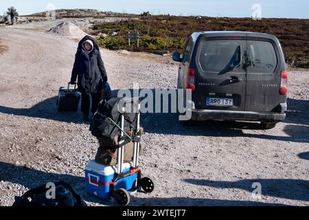 PORTO PRINCIPALE, JURMO, REMOTA ISOLA DEL MAR BALTICO, SOLE INVERNALE: I passeggeri si preparano a salire a bordo del traghetto tra le isole. Il porto principale in una fresca e soleggiata giornata invernale nella remota isola di Jurmo nell'arcipelago di Turku, in Finlandia. Foto: Rob Watkins. INFORMAZIONI: La remota isola geologicamente intrigante di Jurmo è conosciuta per il suo terreno accidentato, i paesaggi pittoreschi e la flora e la fauna uniche. Jurmo è l'ultima parte fuori terra del sistema geologico di creste Salpausselkä dell'era glaciale, che attraversa la Finlandia. Foto Stock