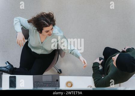 Vista dall'alto di due colleghi in un abbigliamento informale che partecipano a una riunione d'affari. Foto Stock