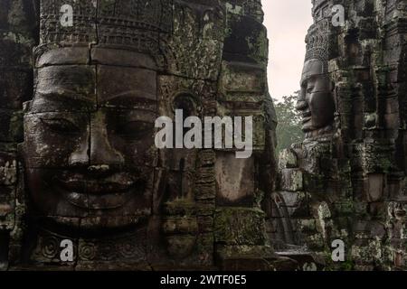 Il Buddha sorridente si affaccia sul tempio Bayon di Angkor Thom vicino a Siem Reap in Cambogia nel sud-est asiatico Foto Stock